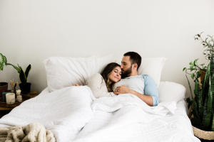 A couple relaxing in bed on organic cotton sheets and organic pillows