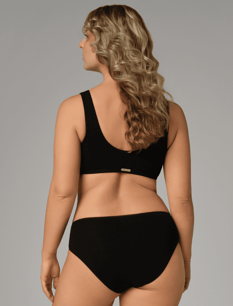 a lady with long hair wearing soft pink organic cotton bralette and knickers 