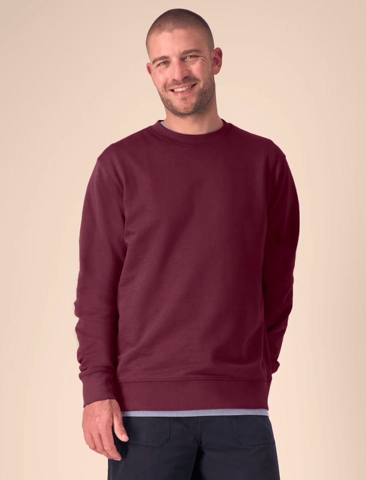 A man and a woman are wearing latte coloured organic cotton sweaters and smiling 