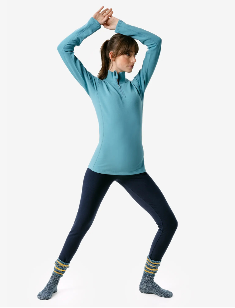 a woman is wearing indigo organic cotton warm leggings and a fleece top 