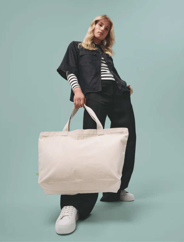 a black organic cotton zip up tote with a stripey top inside 