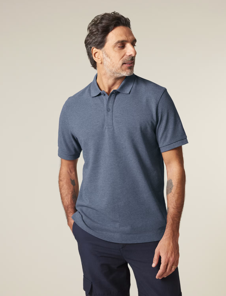 A man is wearing a blue heather organic cotton polo shirt 