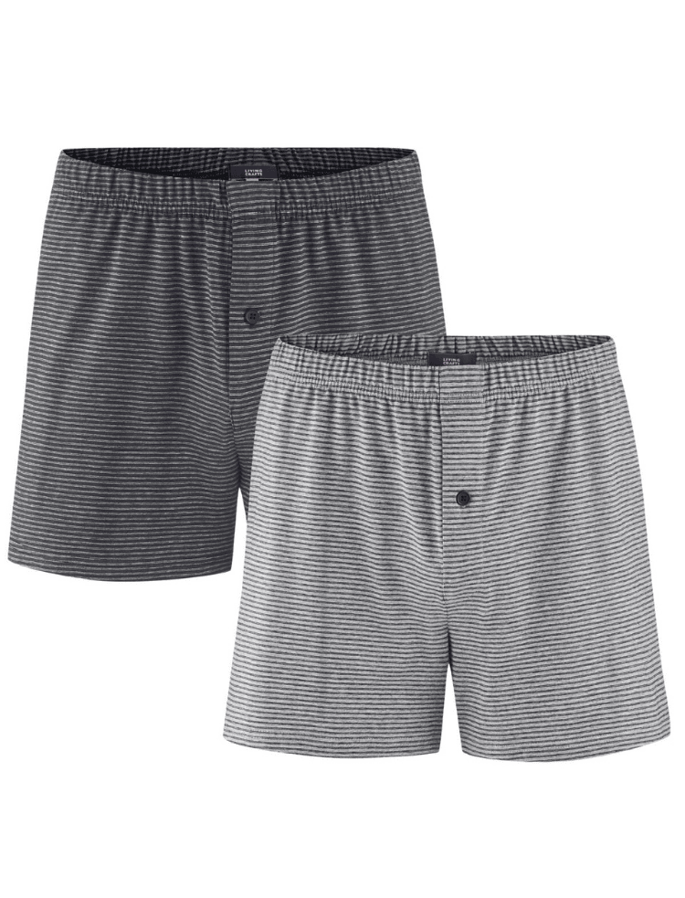A man wearing dark grey organic cotton boxer shorts with light grey stripe with a button fly, on a light grey background 