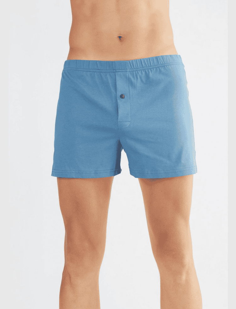 a man is wearing dark red organic cotton boxer shorts and sat on a chair
