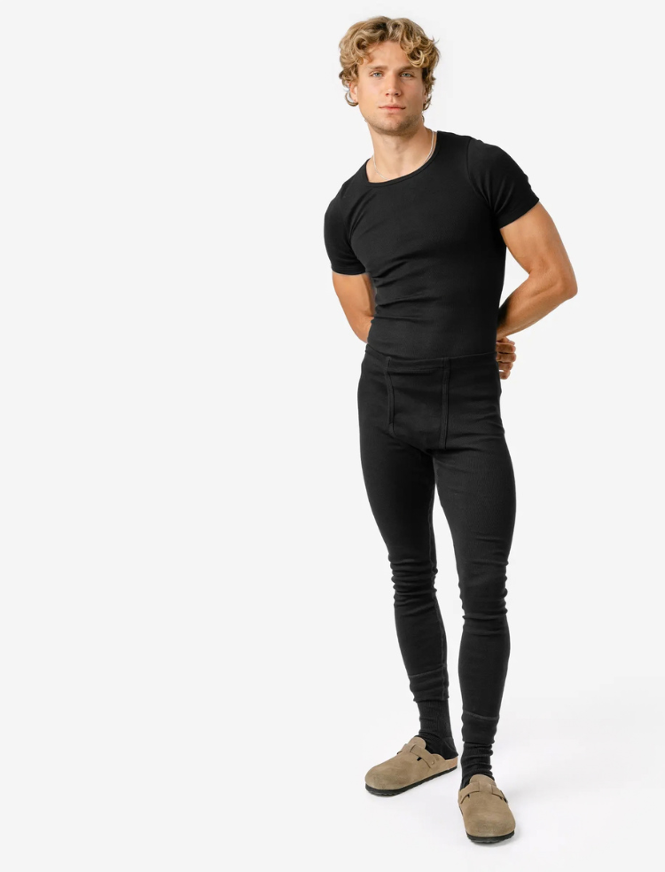 a man is wearing navy organic cotton long johns and a long sleeve vest 