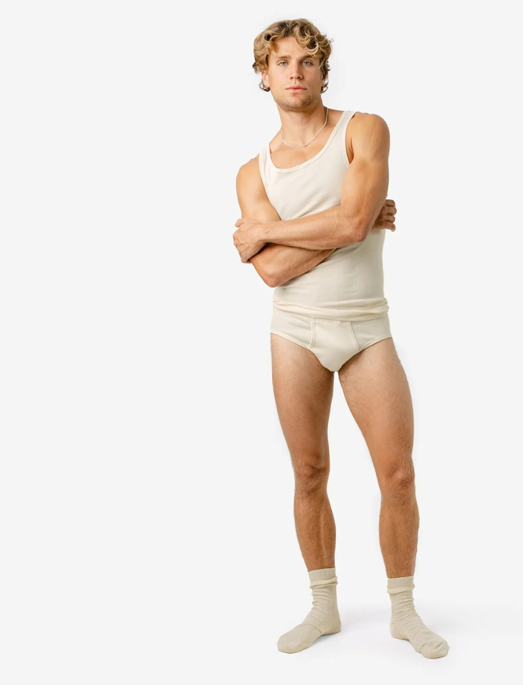 A man in a navy organic cotton vest and pants looking downwards