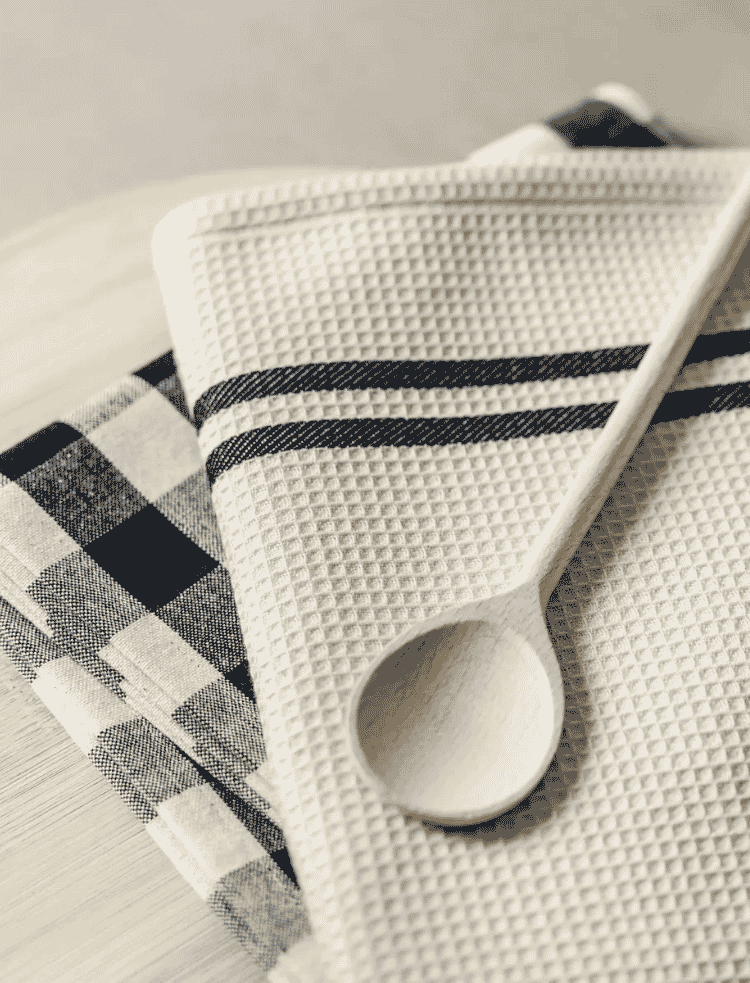 A waffle and check organic cotton tea towel set with wooden spoon