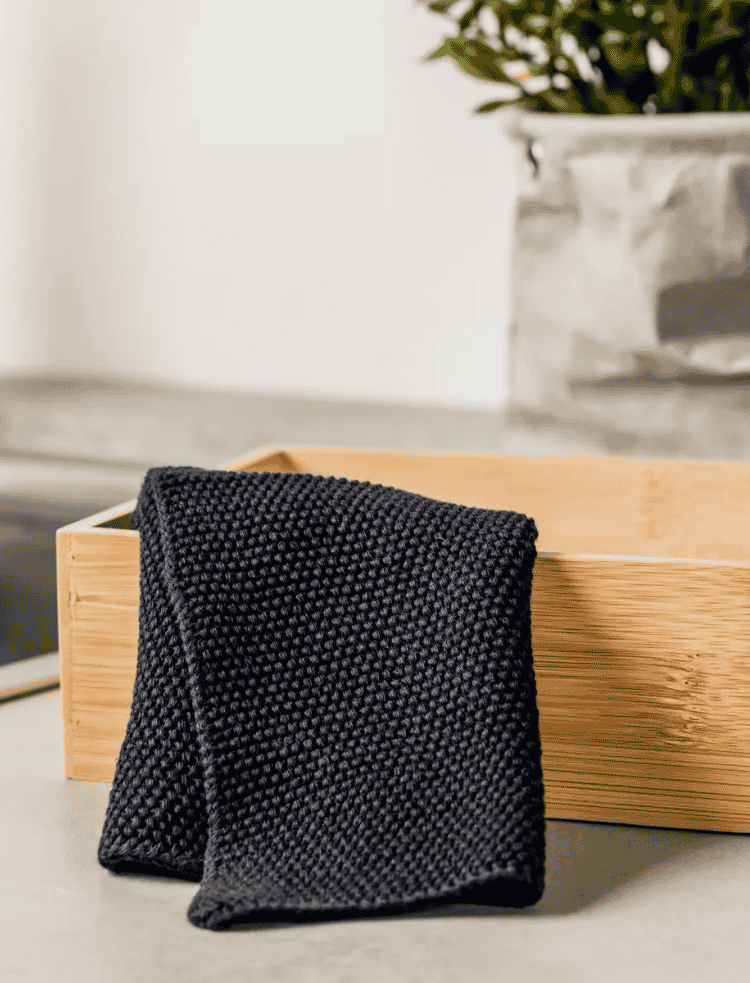 green organic cotton dishcloth draped over a container 