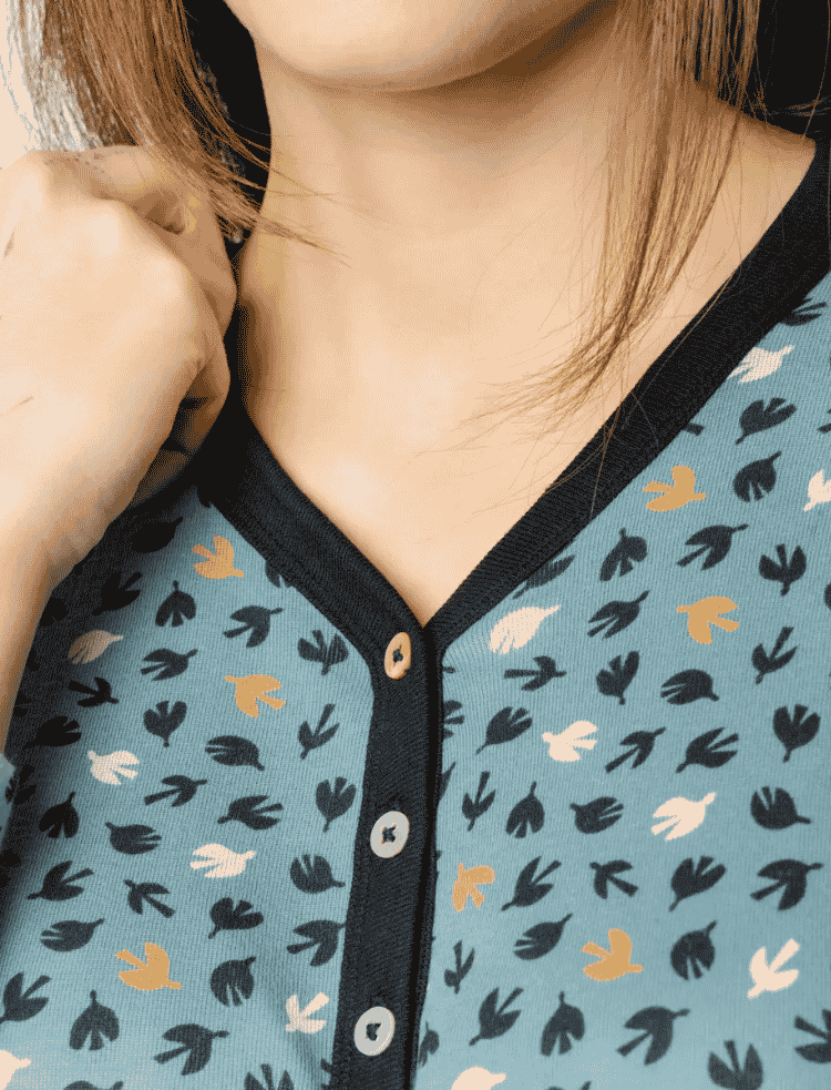 a woman is wearing a long sleeve light blue bird print organic cotton nightshirt