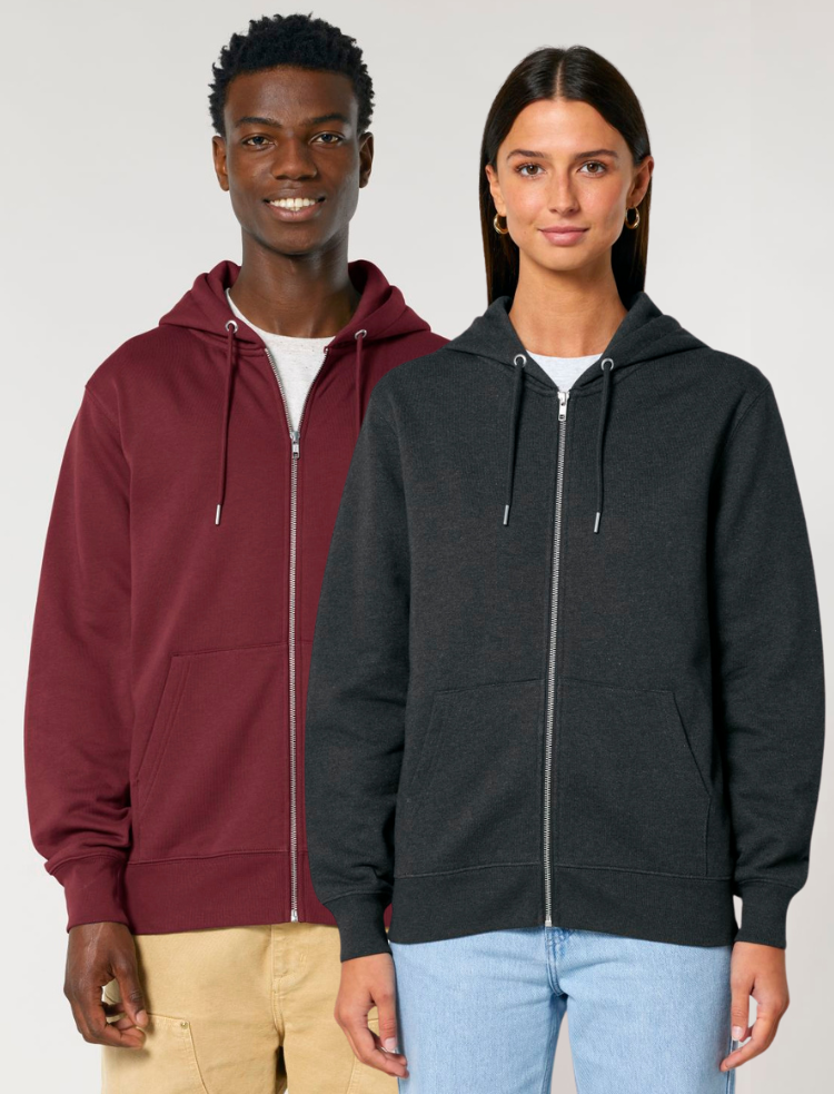 A man wearing an organic burgundy zip hoodie, and a woman wearing an organic dark heather grey zip up hoodie. 