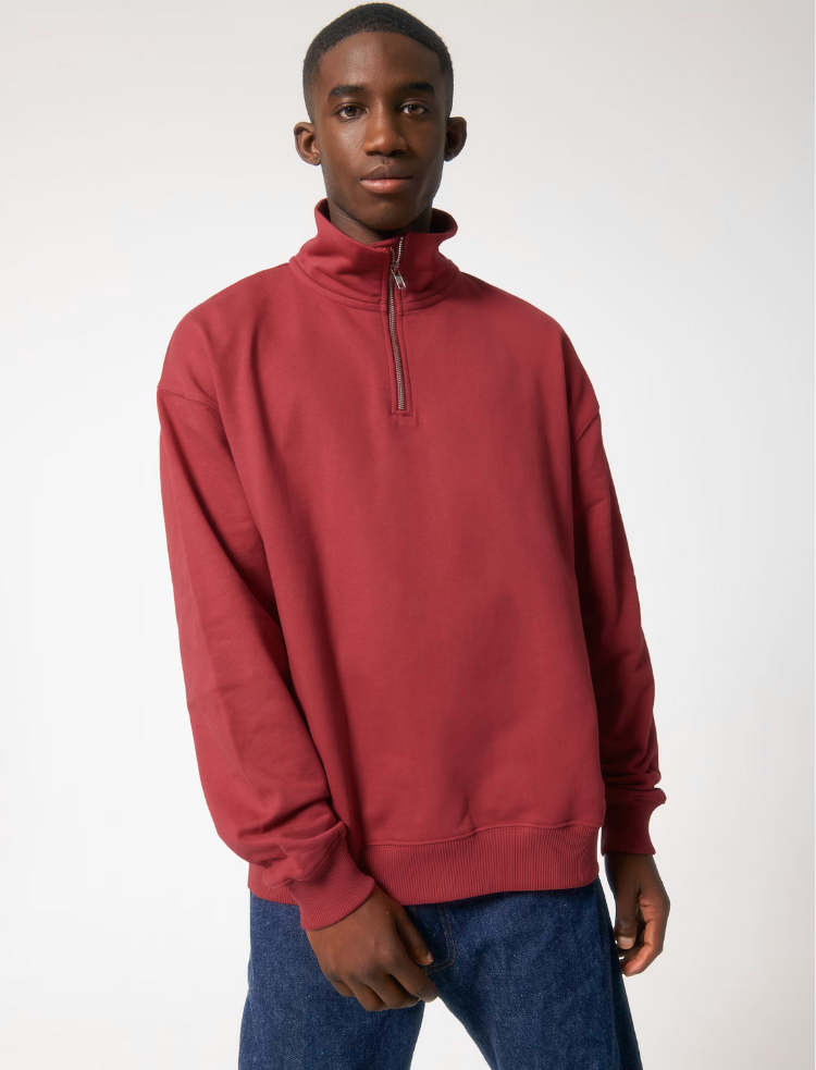 a man and a women wearing red organic cotton quarter zip sweatshirts and blue jeans 