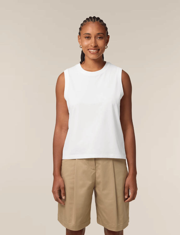 a woman is wearing a white organic cotton sleeveless tank top and smiling 