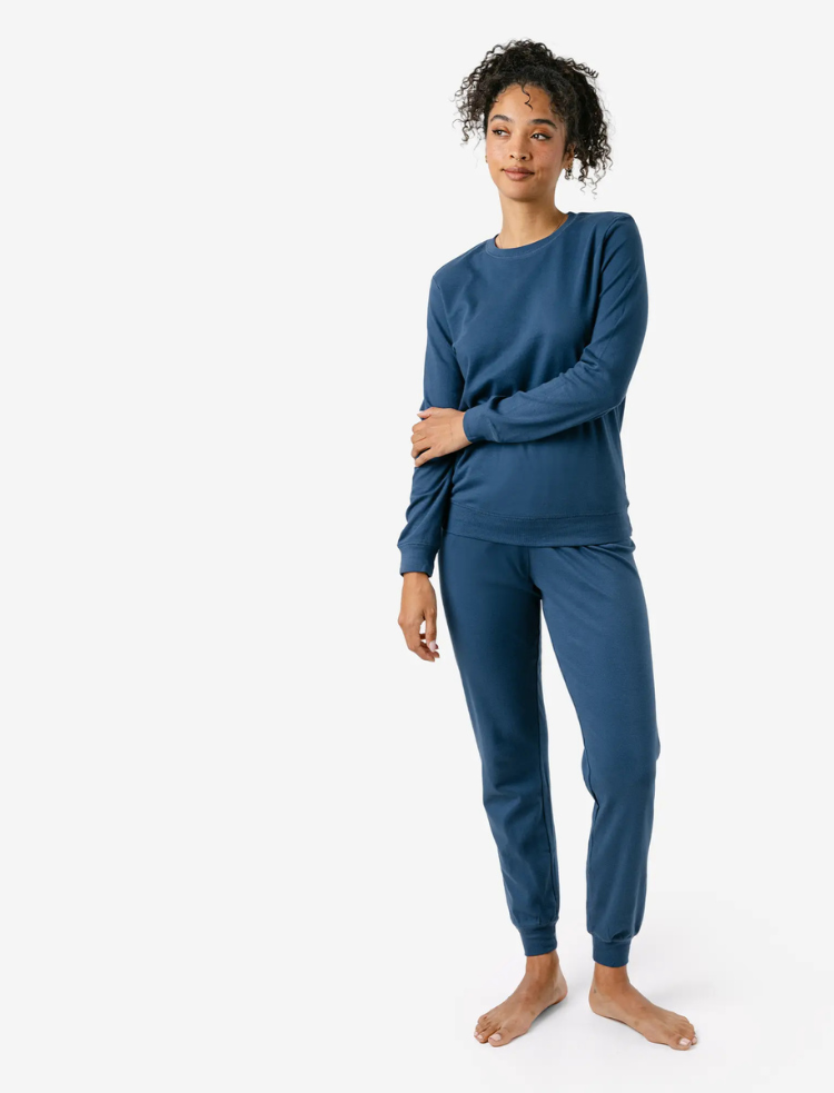 A woman wearing organic cotton mauve coloured pyjamas 