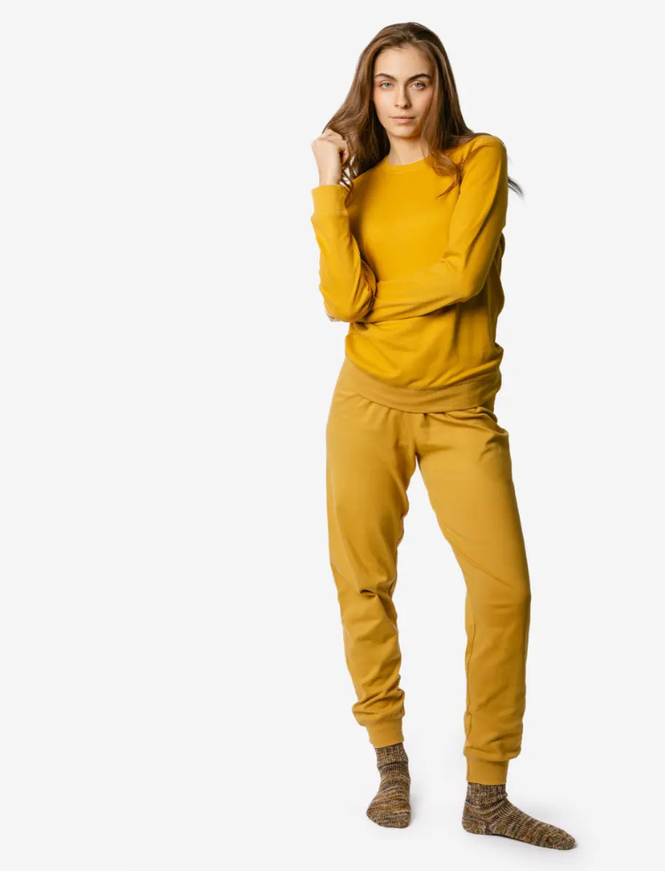 A woman is wearing ochre organic cotton pyjamas