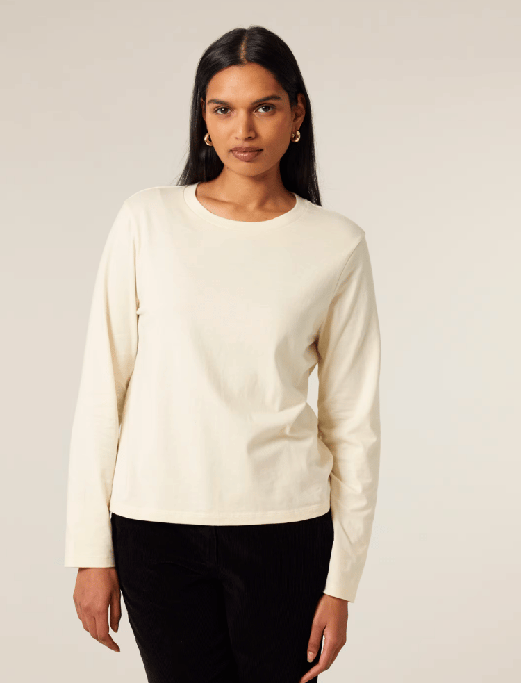 A woman is wearing an undyed long sleeve organic cotton t-shirt 