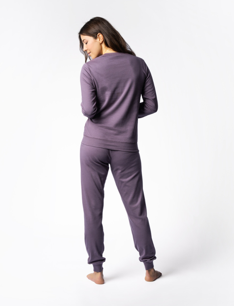 A woman wearing organic cotton mauve coloured pyjamas 