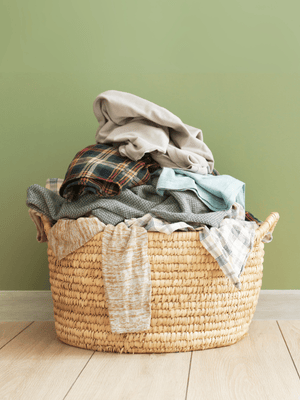 A pile of natural coloured laundry in a wicker basket