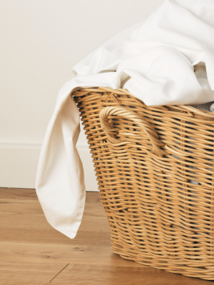 A wicker basket filled with organic cotton sheets 