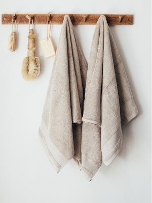 natural coloured cloths and wooden brushes hanging on wooden pegs