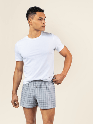 a man is wearing a white organic cotton t-shirt and organic cotton flannel boxer shorts