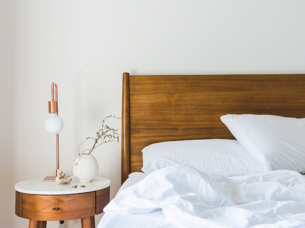 white organic pillows and bedding on a wooden bed