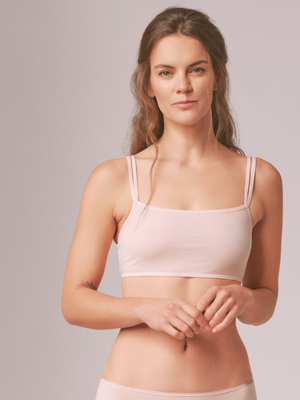 a woman wearing pale pink organic cotton bralette and knickers
