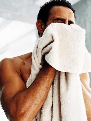 A man is drying his face with an organic towel