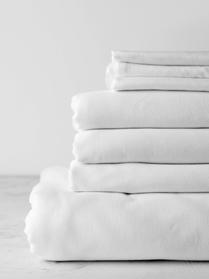 a stack of freshly laundered white cotton sheets